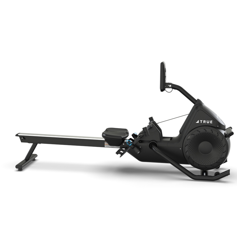 A modern black rowing machine with a digital display, footrests, and a padded seat on a rail, designed for indoor exercise; the brand TRUE is visible on the side.