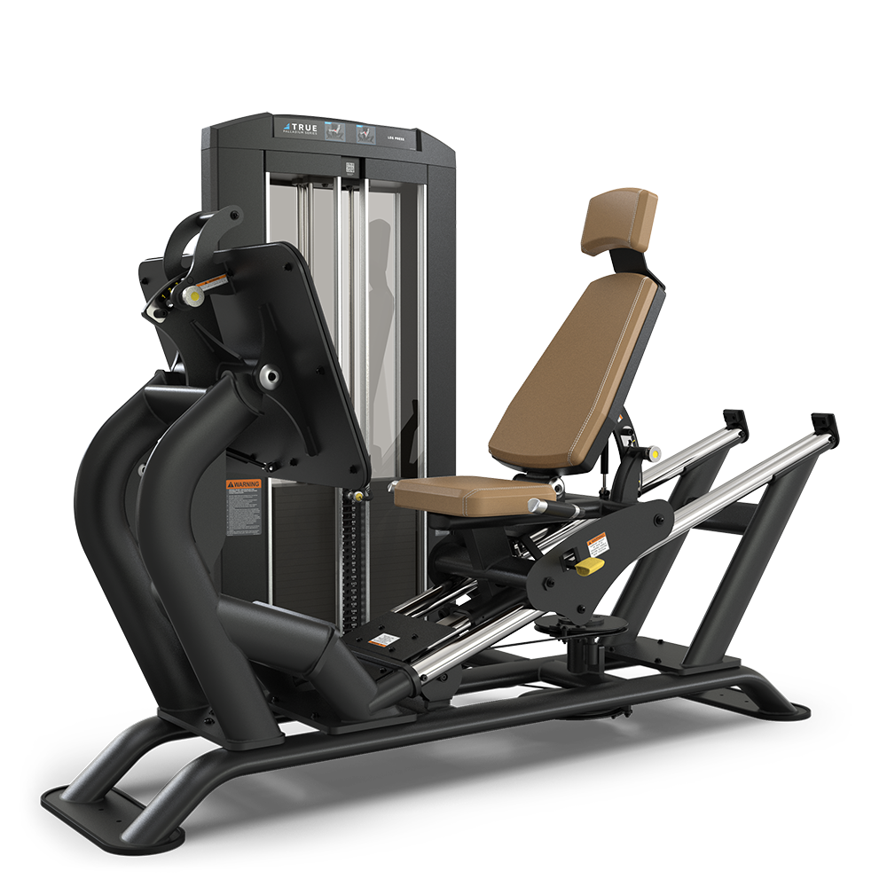 A leg press machine with a padded brown seat and backrest, black frame, footplate, and weight stack, designed for lower body strength training in a gym.